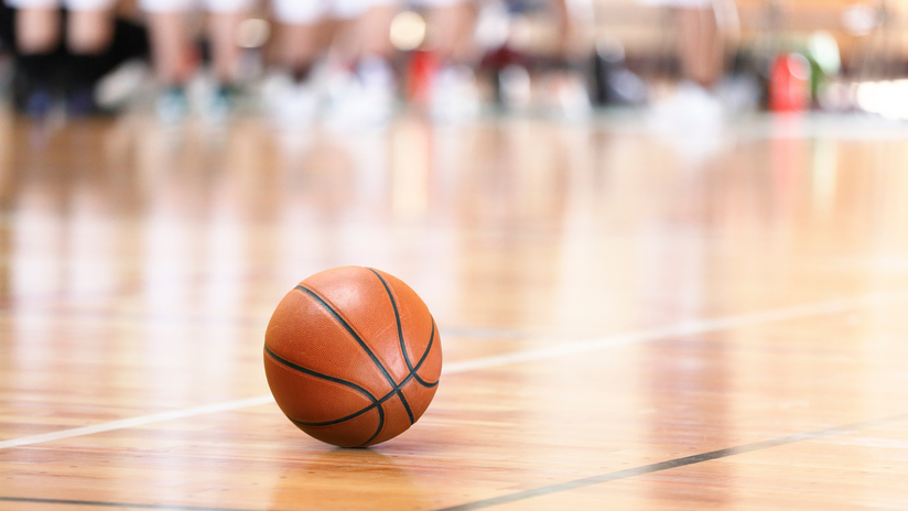 photo of a basketball with a blurred background of the court