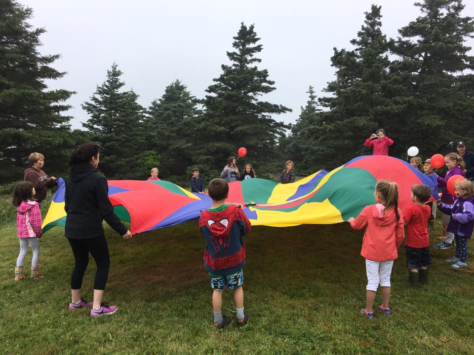 Children in a circle holding a parachute